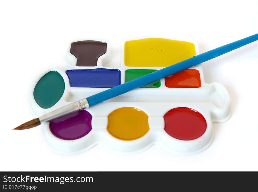 Box of watercolors and a brush isolated on a white background. Box of watercolors and a brush isolated on a white background.