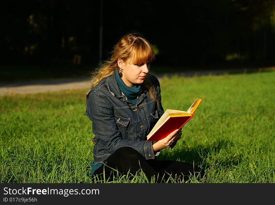 Girl reading the book sitting on the grass