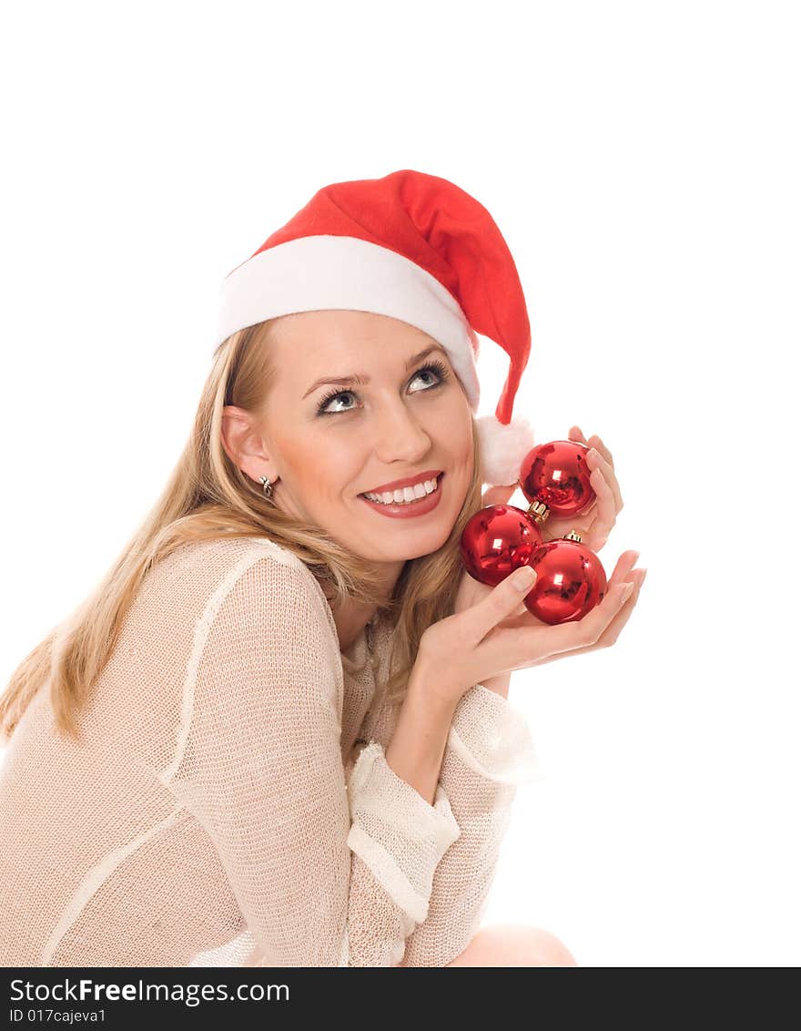 Winter portrait of a joyful woman in Santa hat holding a red christmas ball in her hands. Isolated on white