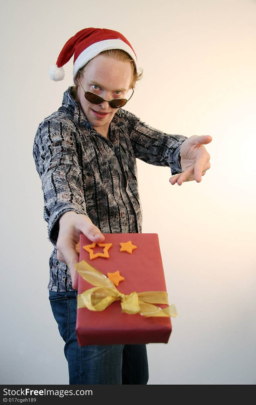 A showoff wearing an xmas hat going wild about a christmas present. A showoff wearing an xmas hat going wild about a christmas present.