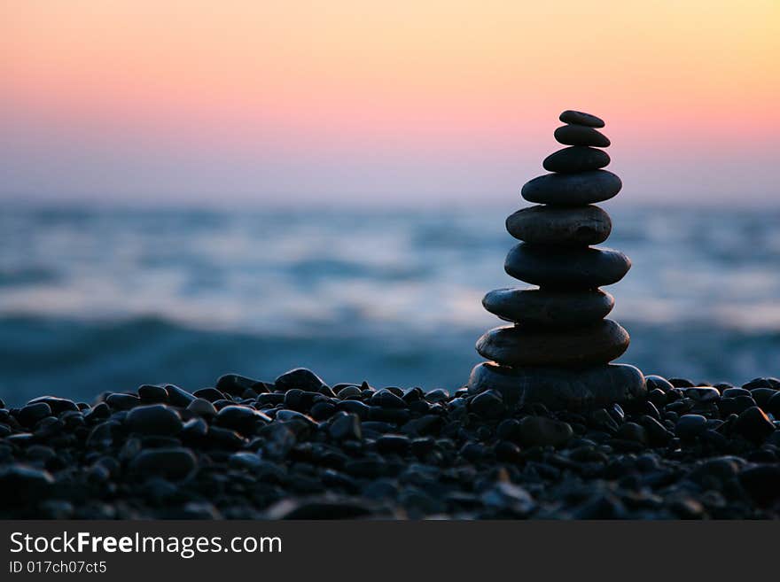 Small pyramid from stones on sunset seacoast