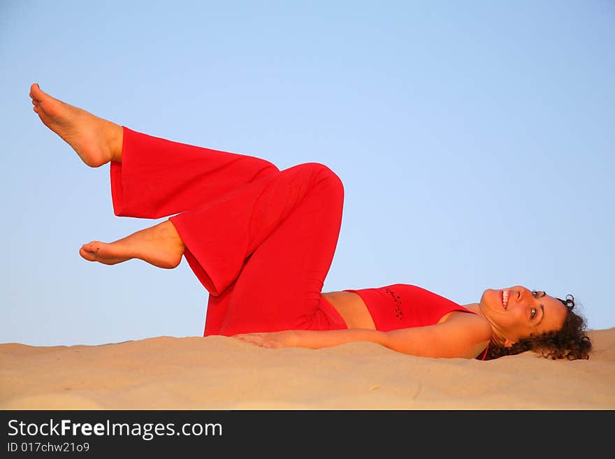 Young woman in red lies on sand