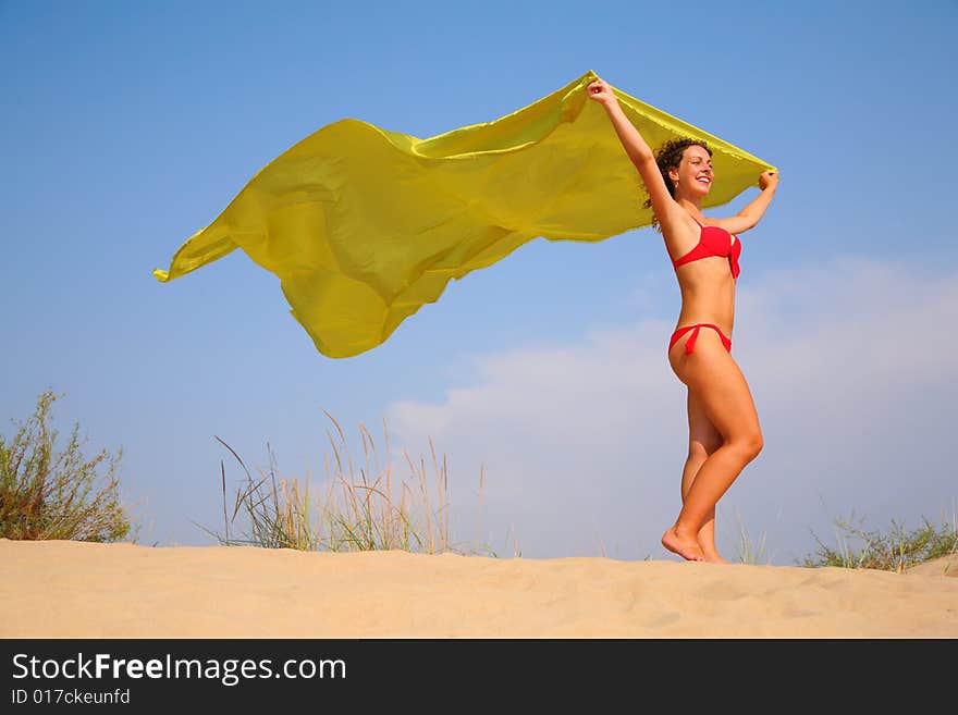 Young Girl On Sand With Yellow Shawl In Hands