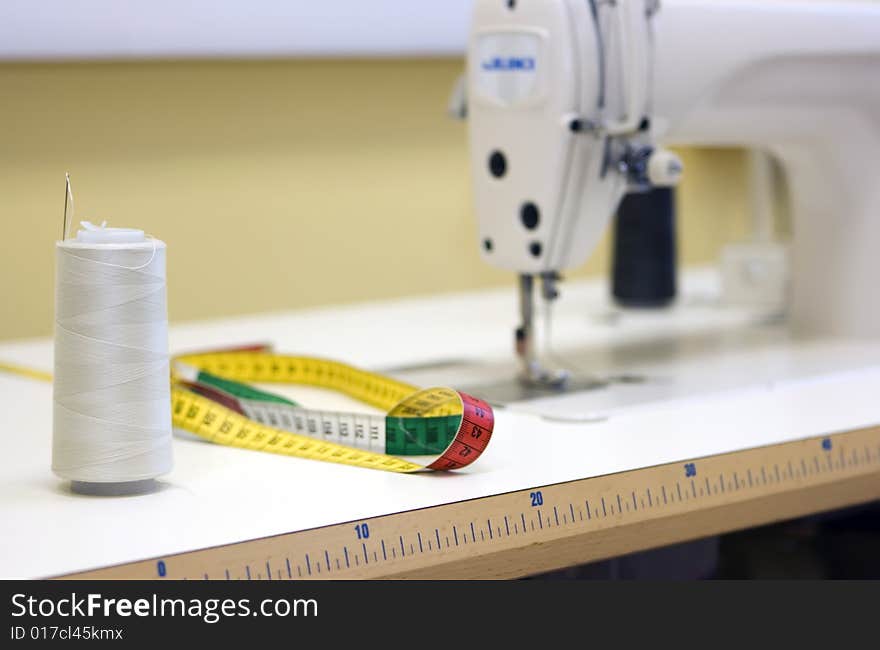 A sewing machine and thread spool on a table