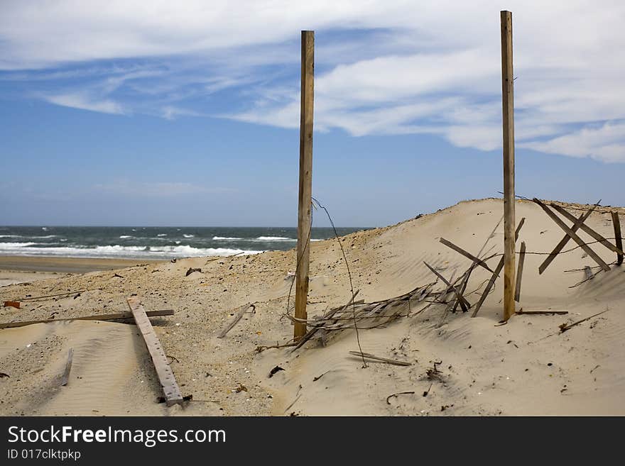 A windy beach with a fence that is in place to keep the sand in place. The picture is taken at the Outer Banks, NC, USA