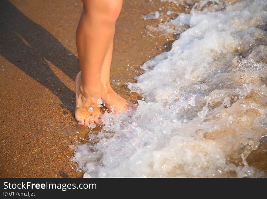 Legs on wave on sand