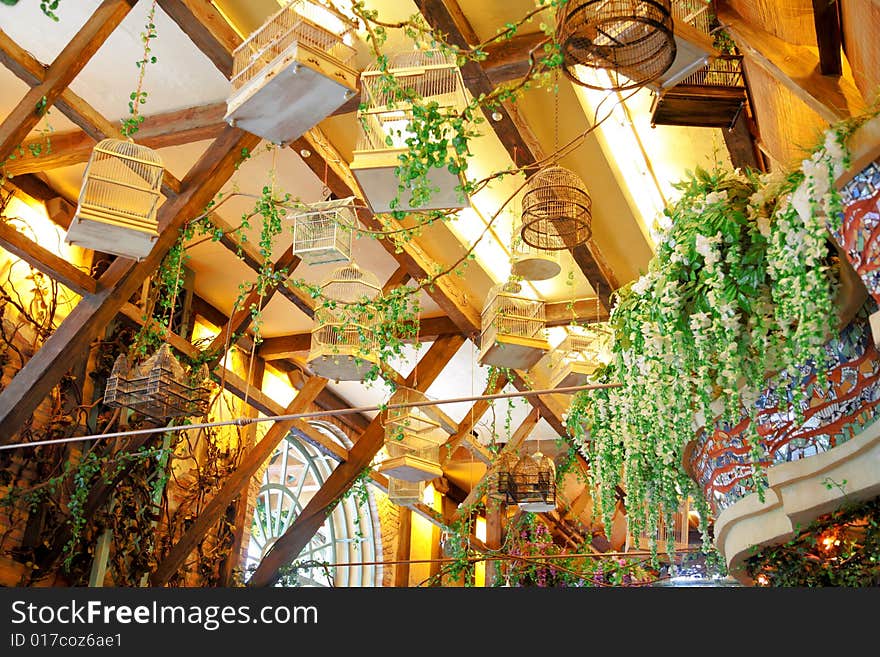 Empty bird's cages hang under ceiling, indoor