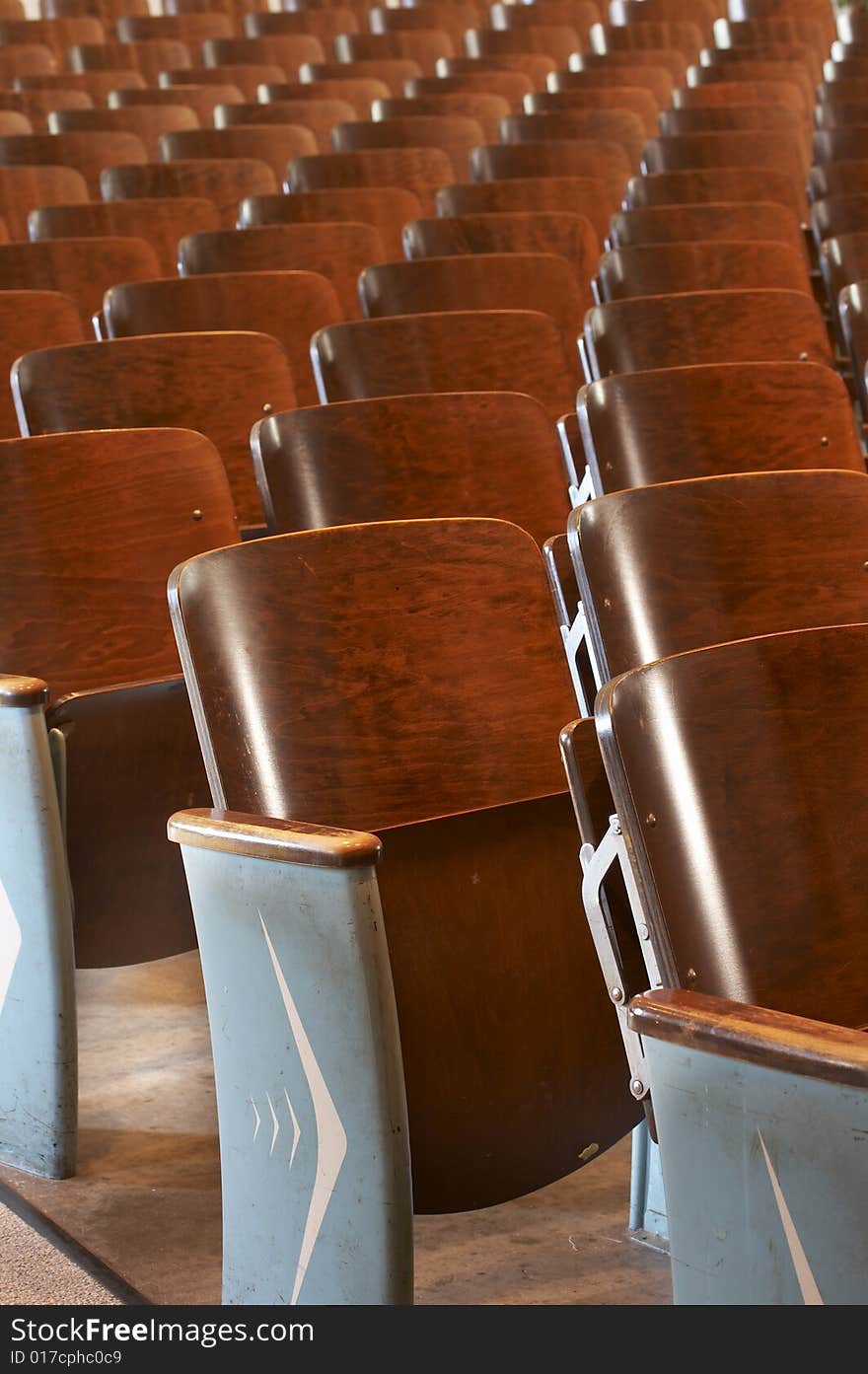 Rows of wood chairs in an old auditorium. Rows of wood chairs in an old auditorium