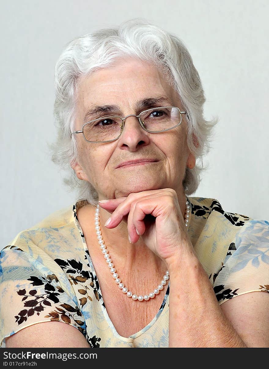 Portrait of senior lady over a gray background