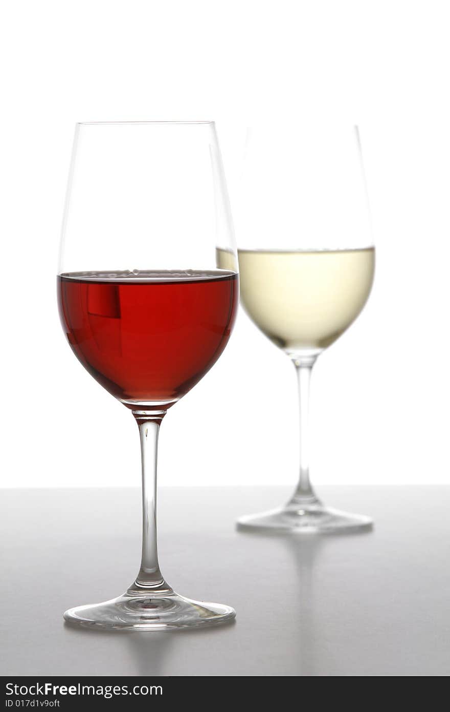 Two wine glasses one red one white in the studio