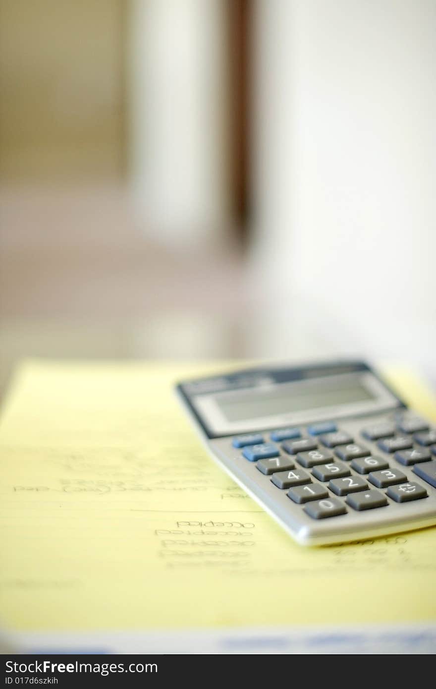 A calculator on a legal pad in an office. A calculator on a legal pad in an office