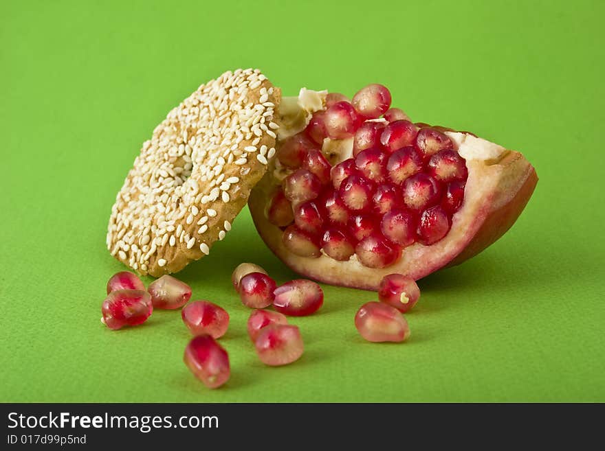 Pomegranate and cookies close-up isolated on green background. Pomegranate and cookies close-up isolated on green background