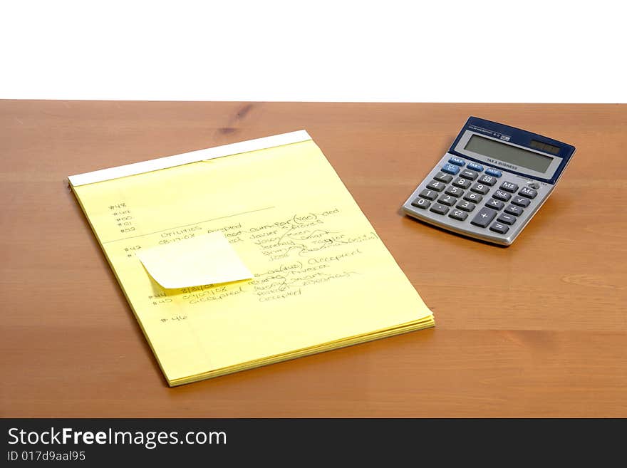 A calculator on a legal pad in an office. A calculator on a legal pad in an office