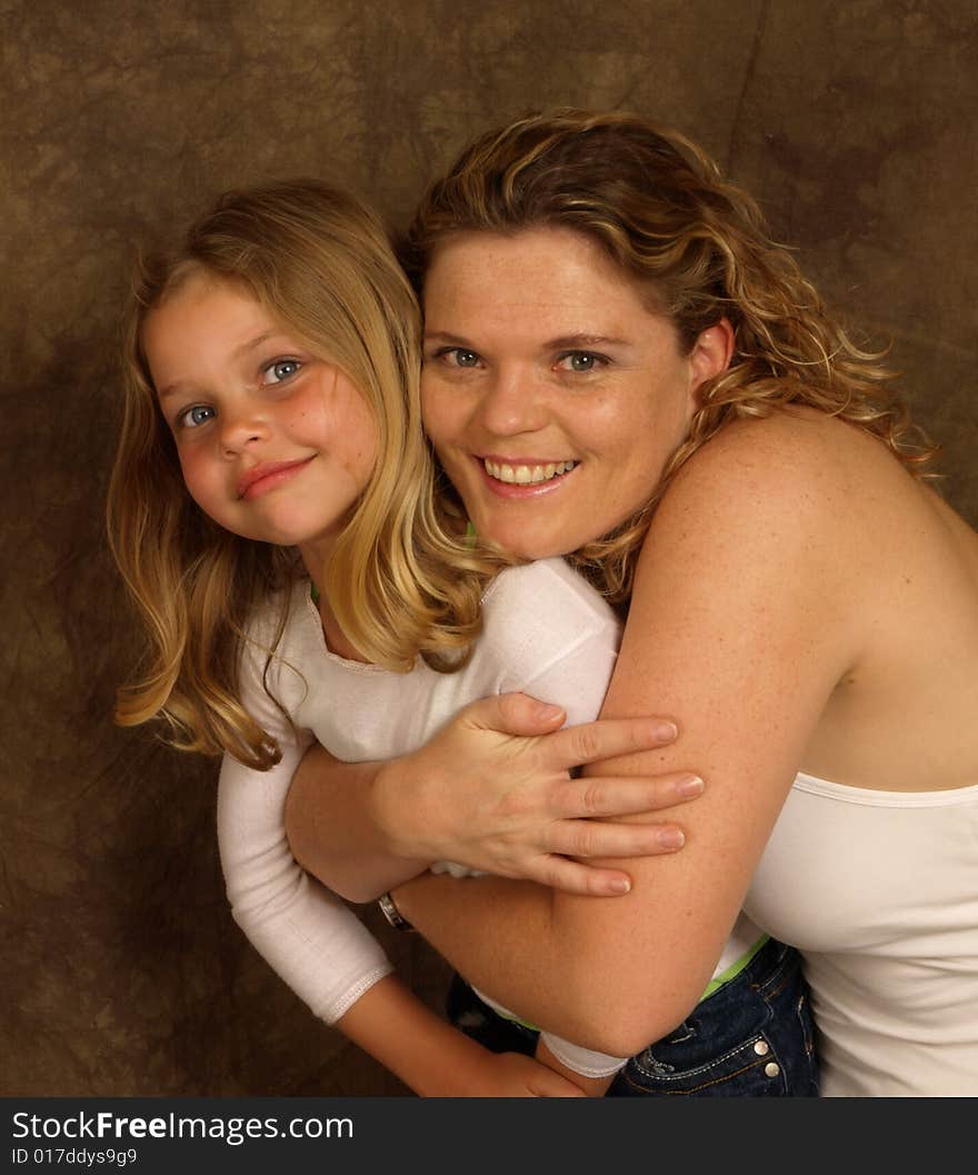 A portrait of a mother and daughter hugging. A portrait of a mother and daughter hugging