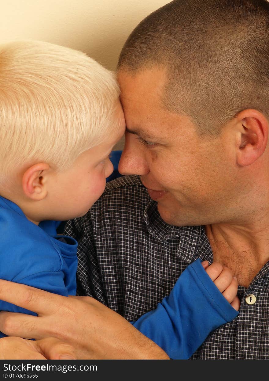 A portrait of a young boy hugging his smiling father. A portrait of a young boy hugging his smiling father