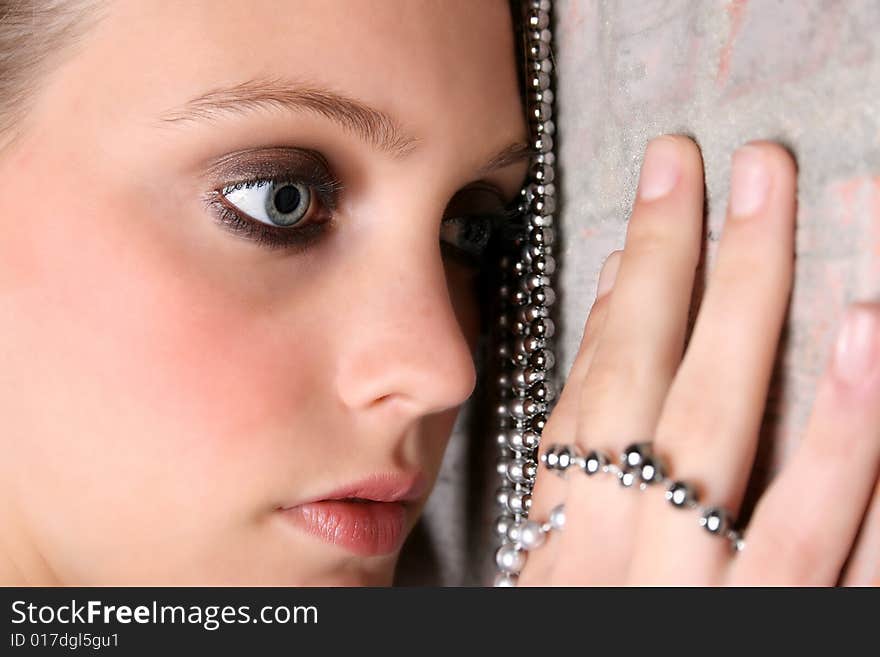 Beautiful model with blue eyes holding strings of beads. Beautiful model with blue eyes holding strings of beads