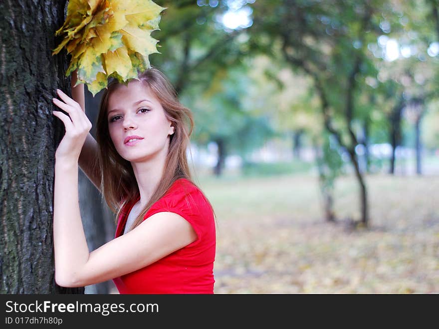 Young beautiful woman in red with yellow maple leaves. Young beautiful woman in red with yellow maple leaves