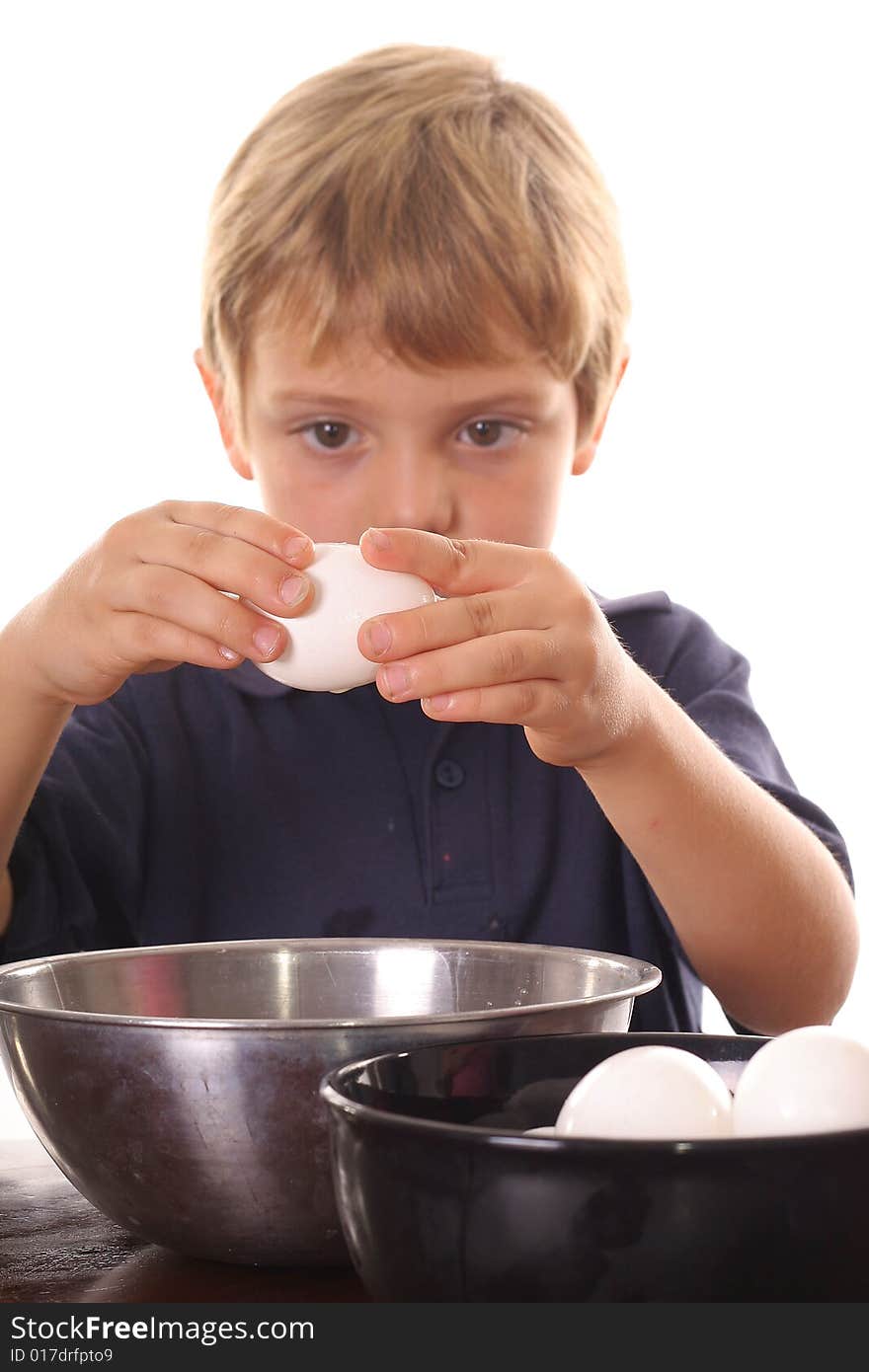 Little boy breaking an egg