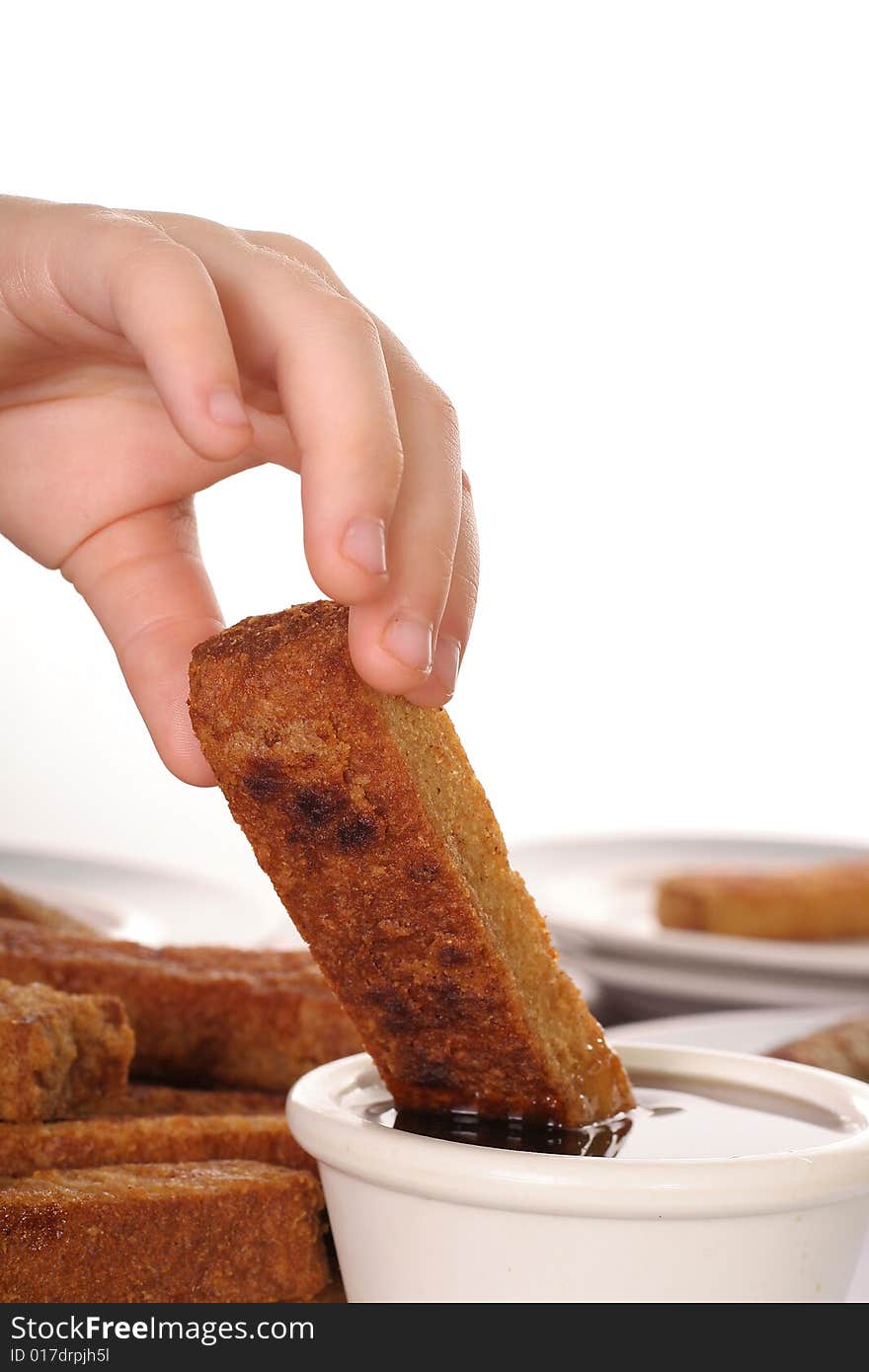 Young Child Dipping French Toast In Syrup