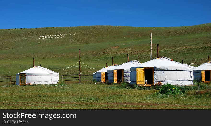 Some several white mongolian yurts in steppe of Mongolia. The doors are opened