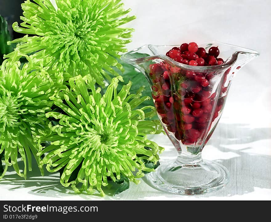 Red berry in glass and flowers