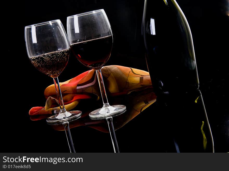 Glass, bottle and shawl on dark background