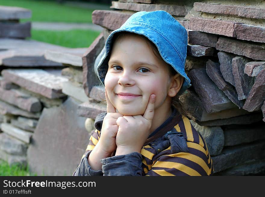 Little girl smiling near stones