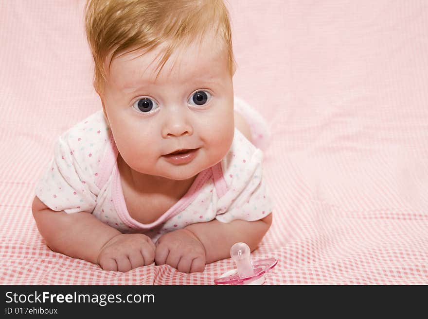 Little baby girl on pink cover