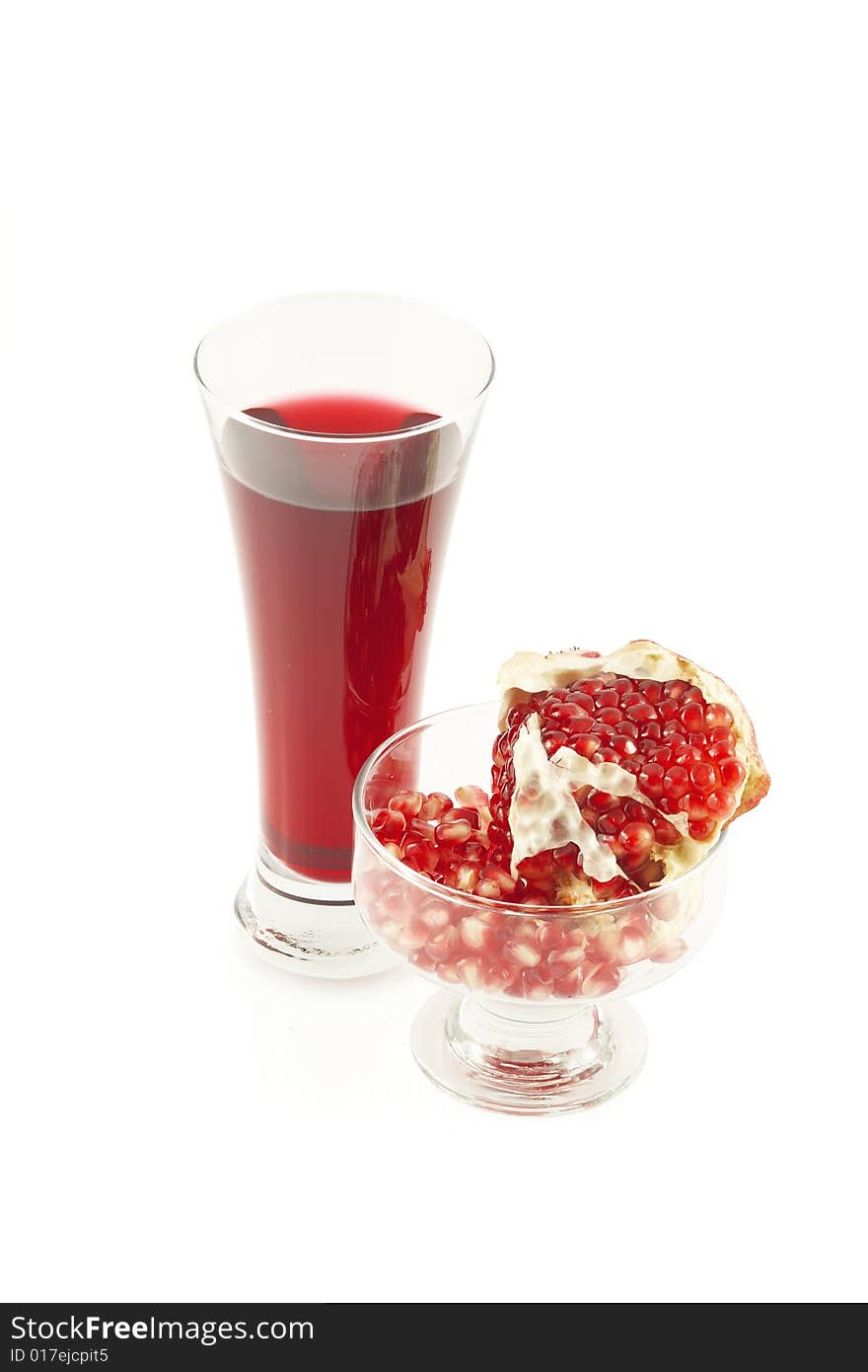 Glass of pomegranate juice and  grains and a pomegranate piece. Over white. Glass of pomegranate juice and  grains and a pomegranate piece. Over white.