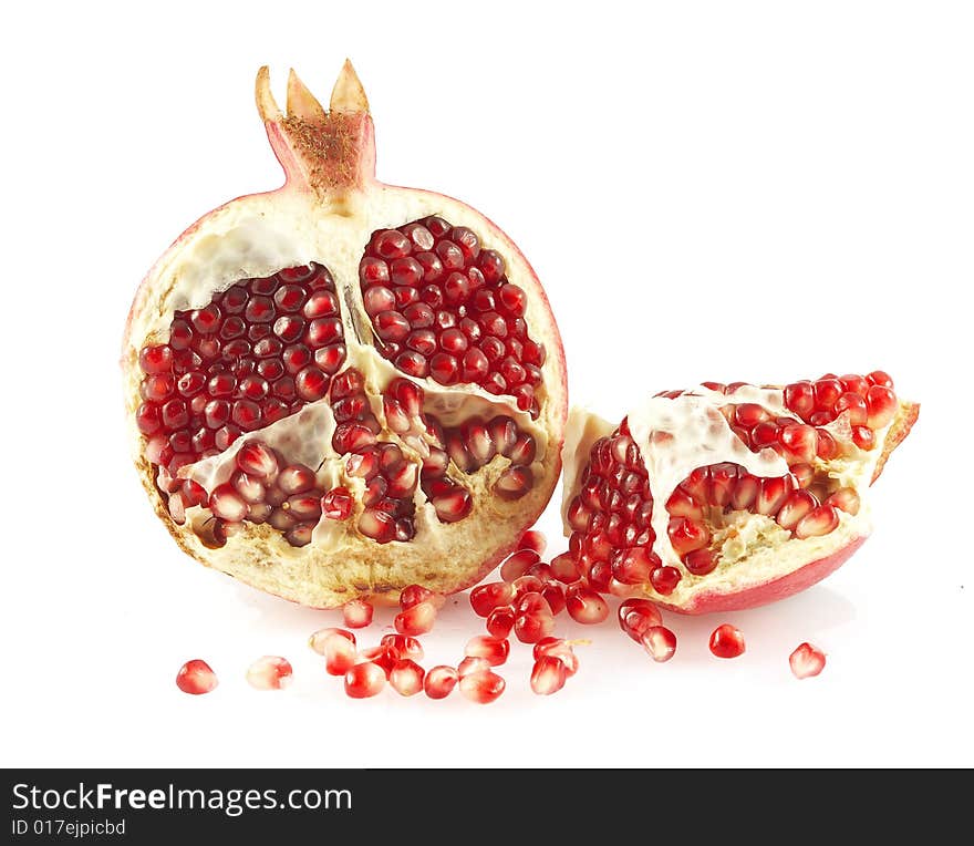 Pieces of a pomegranate and pomegranate grains. Over white. Pieces of a pomegranate and pomegranate grains. Over white.