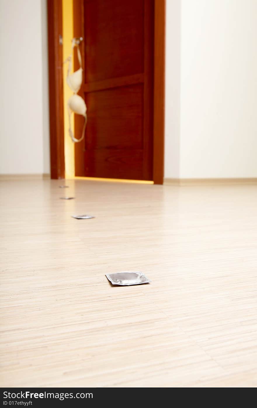 Empty bottle and condoms against a bedroom door. Empty bottle and condoms against a bedroom door