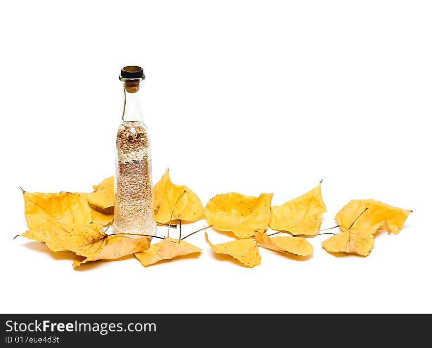 Fall leafs and bottle with groats isolated on white