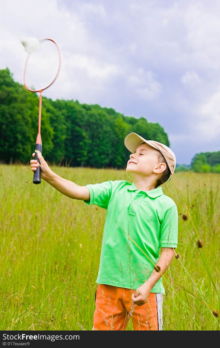 Cute kid playing badminton outdoors