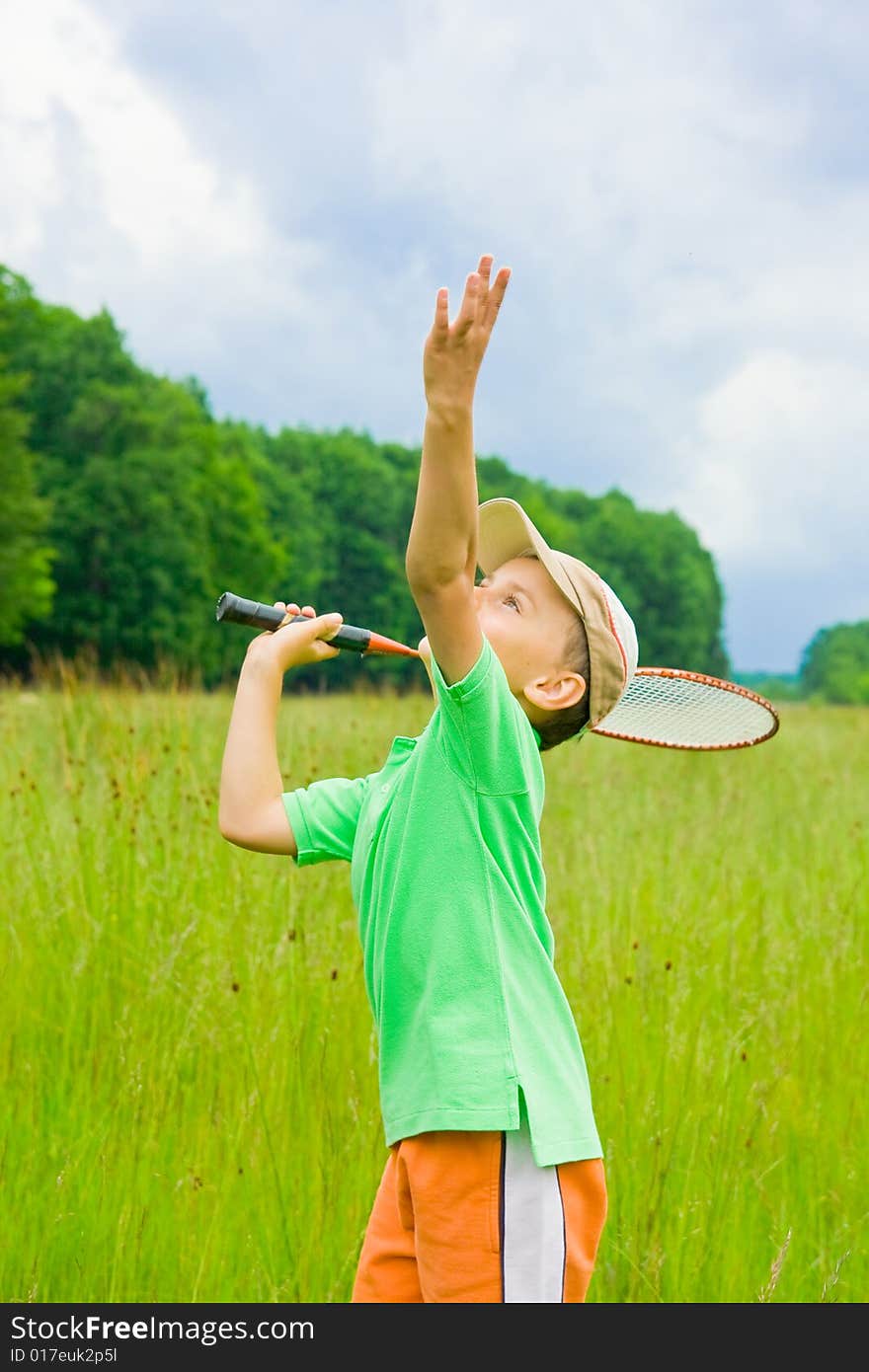 Cute kid playing badminton outdoors