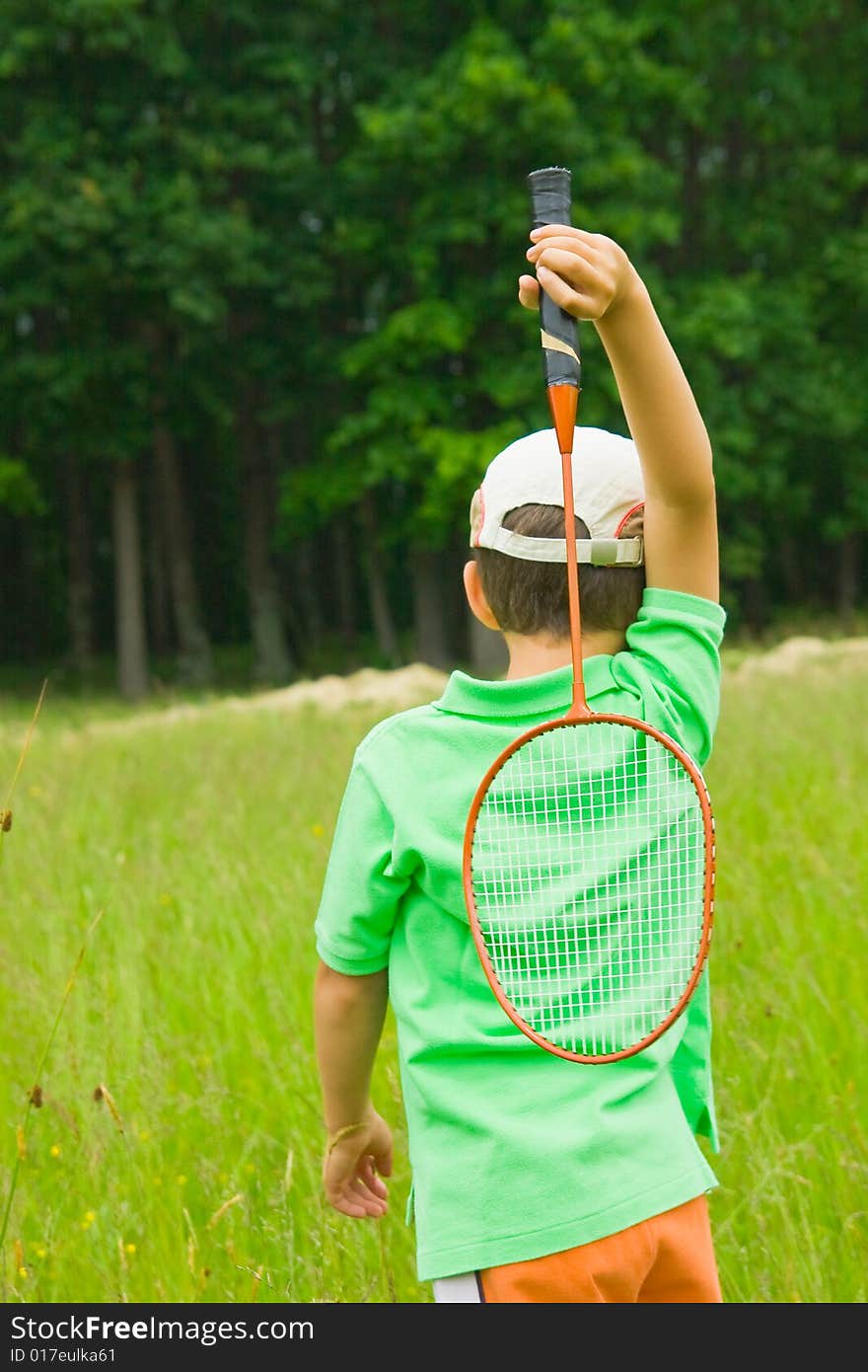 Cute kid playing badminton outdoors