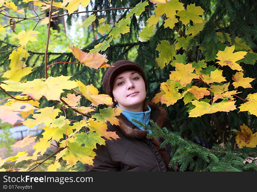 Autumnal portrait of a girl among leaves