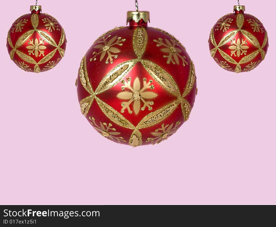 Red and gold Christmas ornaments against pink background. Red and gold Christmas ornaments against pink background