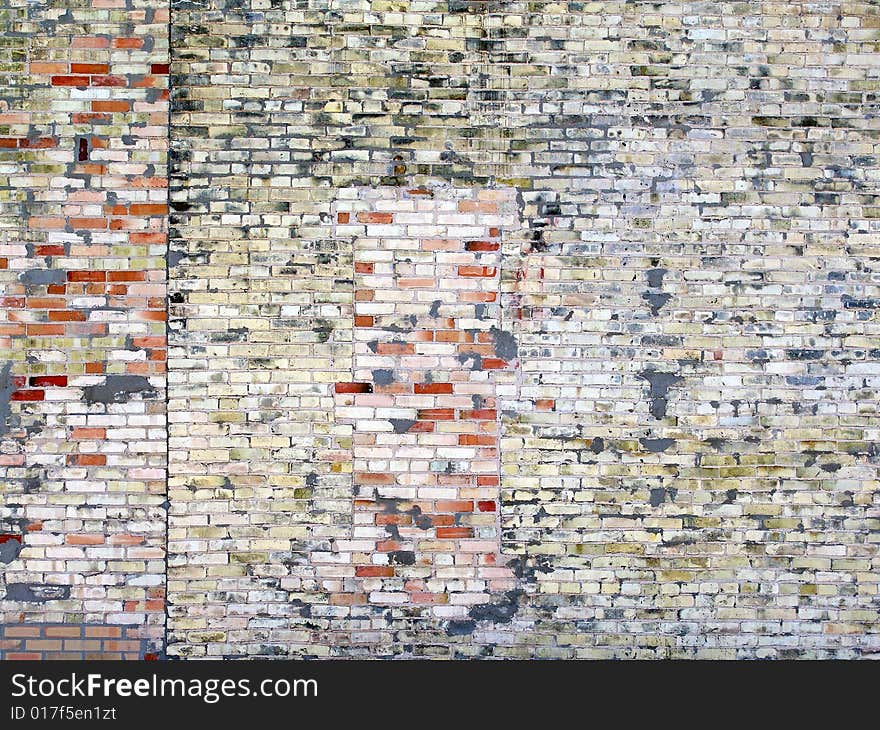 Weathered brick wall with multi-colored painted bricks