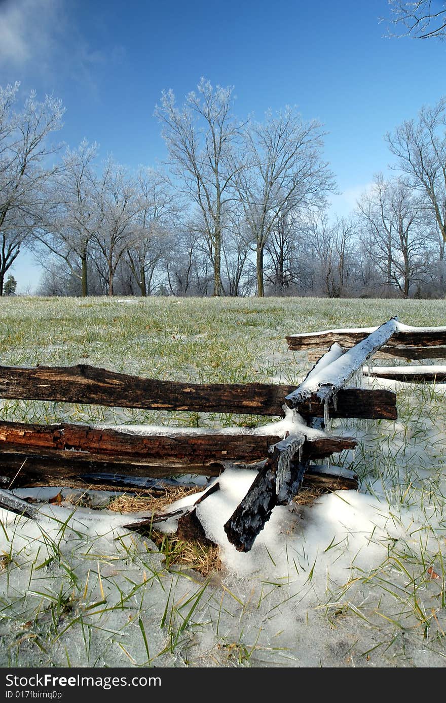 An old fashioned wood link fence covered in snow and ice on an otherwise clear and nice day. An old fashioned wood link fence covered in snow and ice on an otherwise clear and nice day.