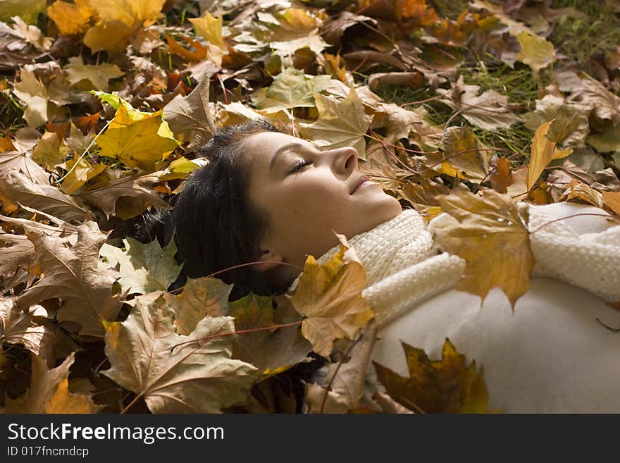 Sleeping autumn day woman lying in leafes. Sleeping autumn day woman lying in leafes