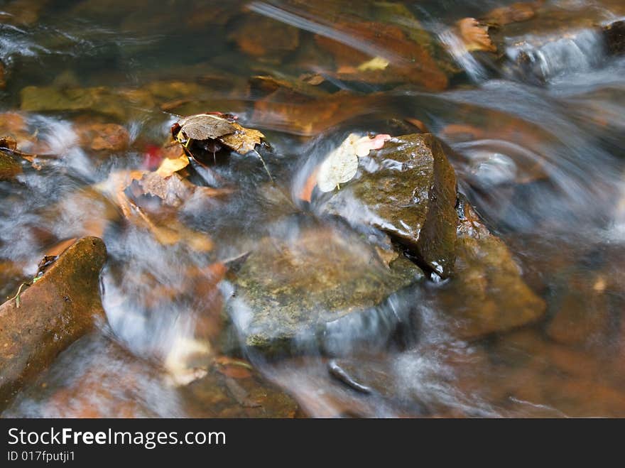 Water flowing over rocks with autumn leaves. Water flowing over rocks with autumn leaves