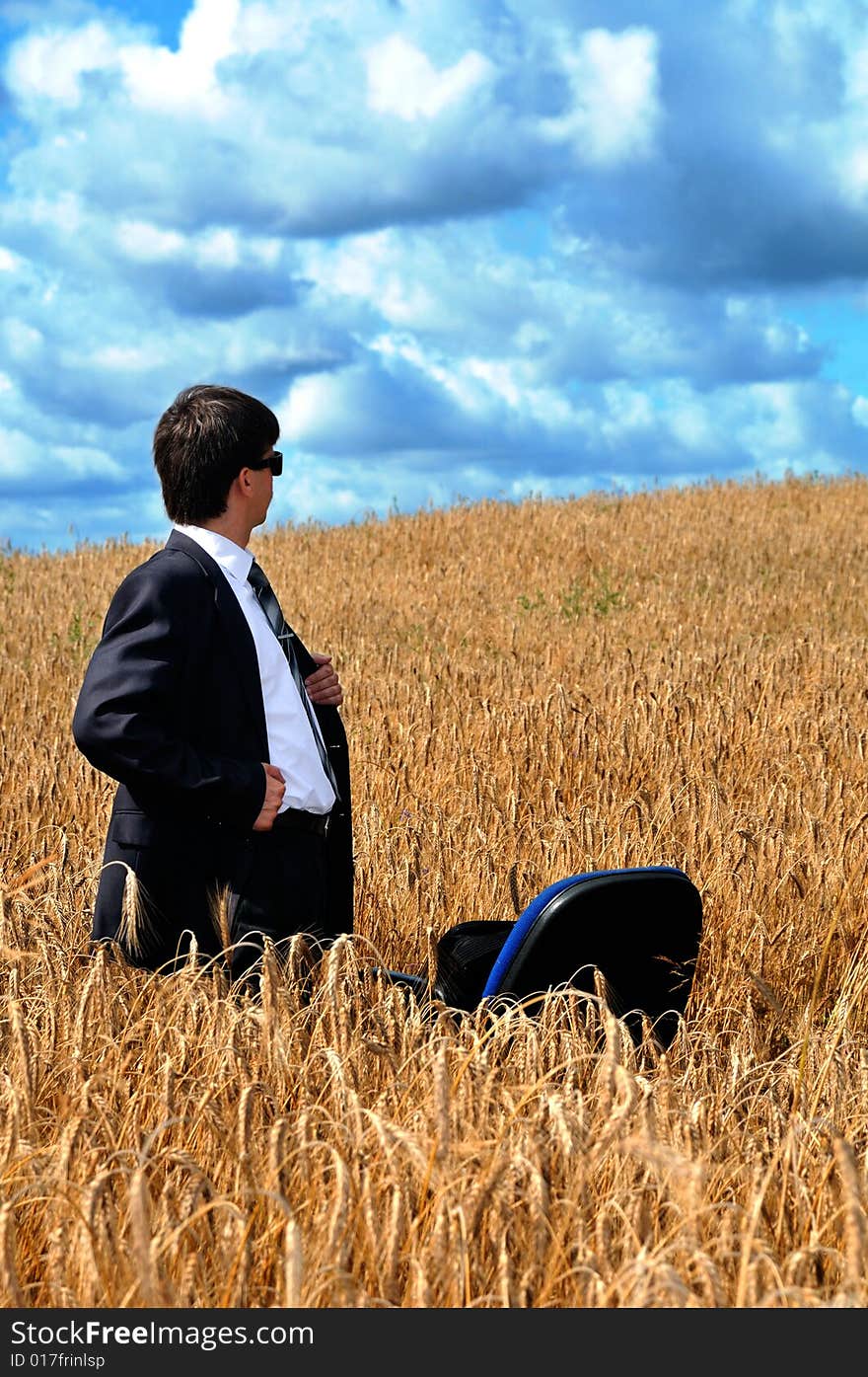 Young successful businessman looks a field