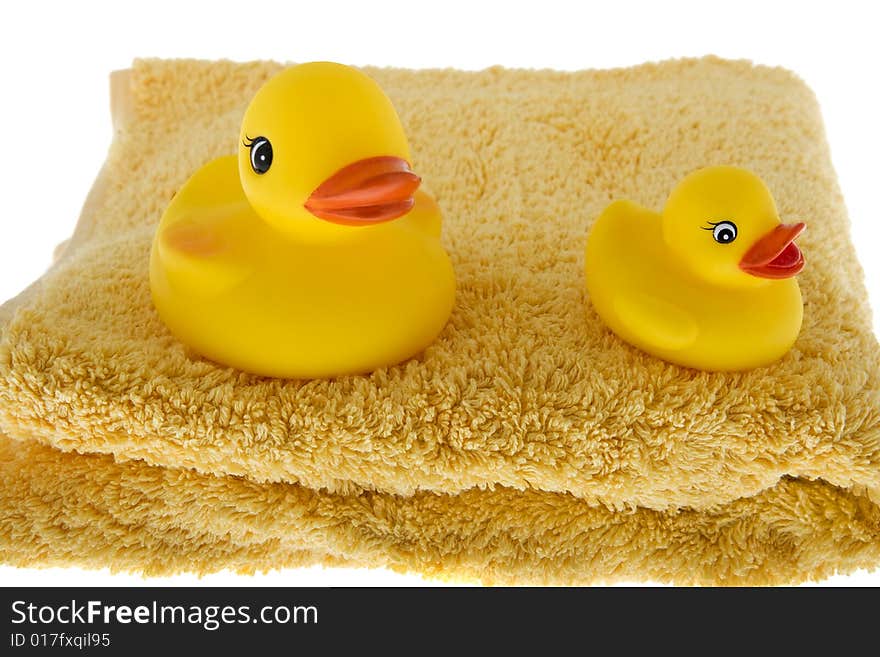 Rubber duck sits on towel, toys made of plastic for taking a bath