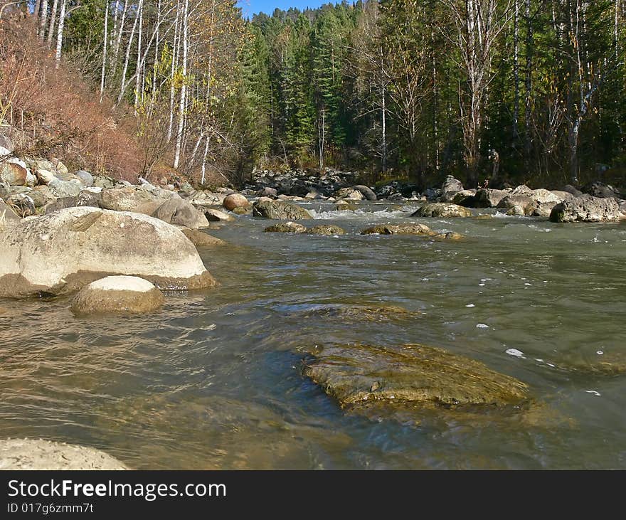 Autumn on the river Yurtok, big stones in water.