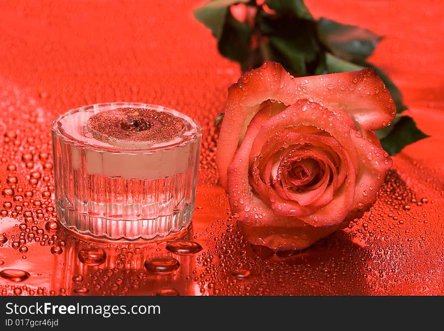 Candle with rose on red background