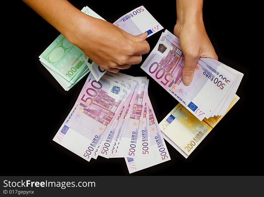 Euro currency in hands on black