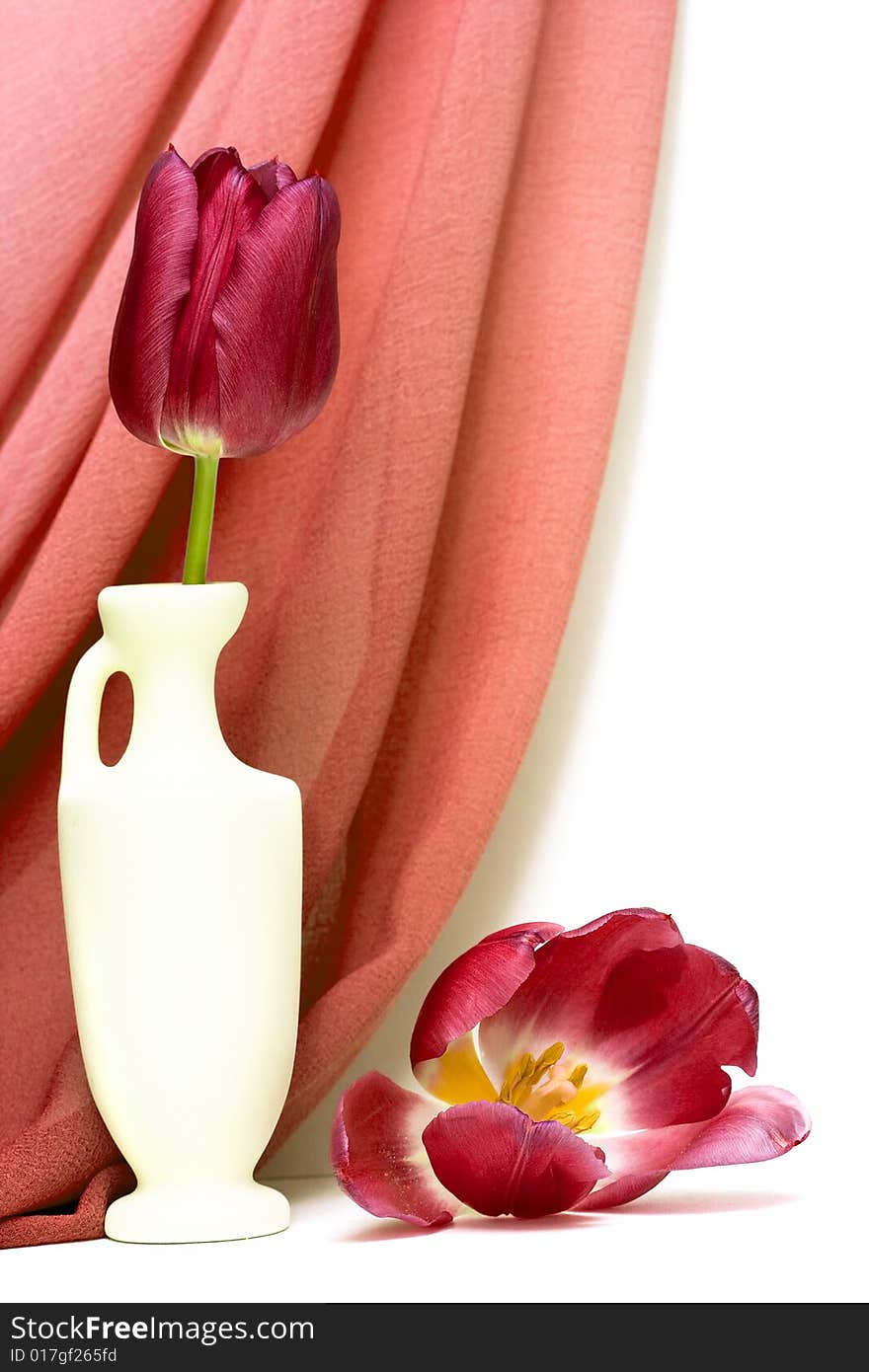 Red flowers in vase with fabric