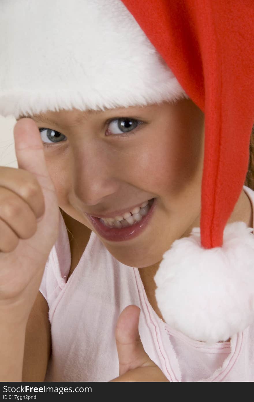 Happy little girl wearing christmas hat showing hand gesture