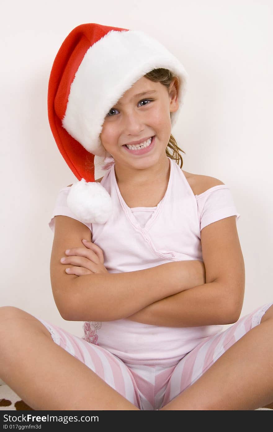 Smiling girl with her arms crossed wearing christmas hat