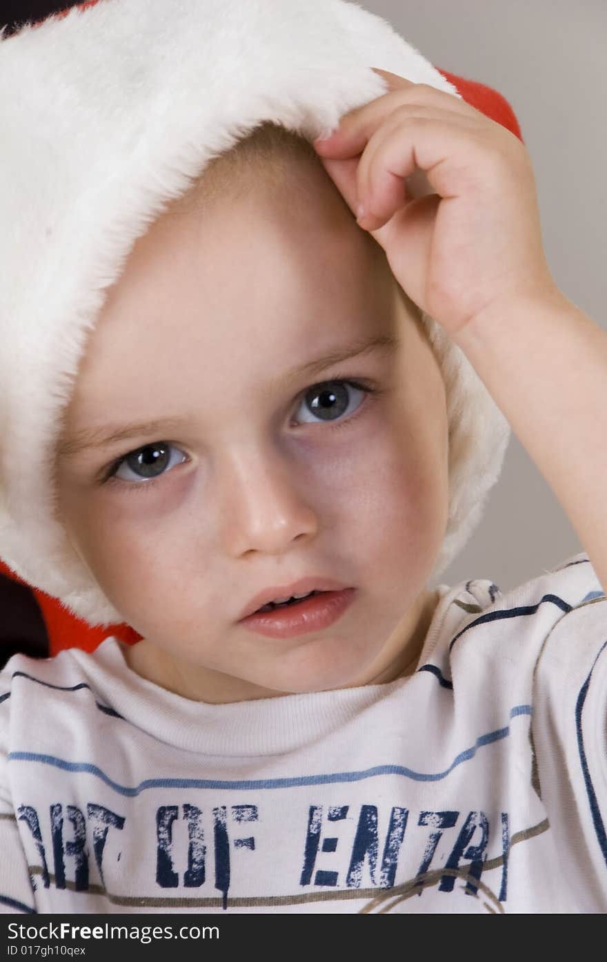 Little boy wearing christmas hat and looking at camera